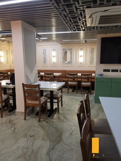 A wider view of the dining room, showing the combination of booth and chair seating to accommodate different party sizes.