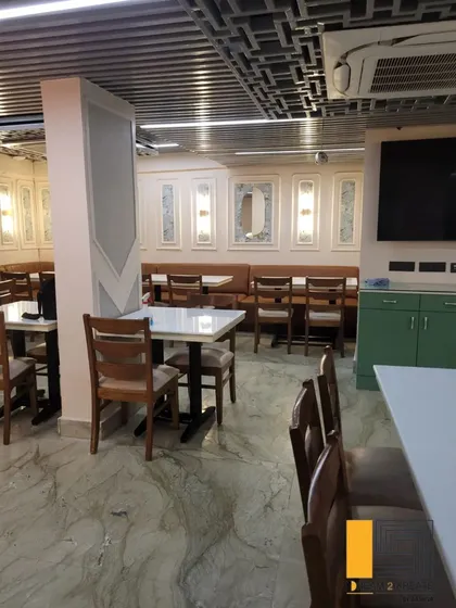 A wider view of the dining room, showing the combination of booth and chair seating to accommodate different party sizes.