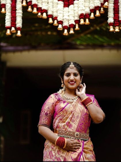 The bride's smile shows the happiness that a beautiful, traditional setting can bring. Our goal is to create a welcoming atmosphere that honors our culture, making moments like these even more special. This entrance decor is perfect for a mane pooje.