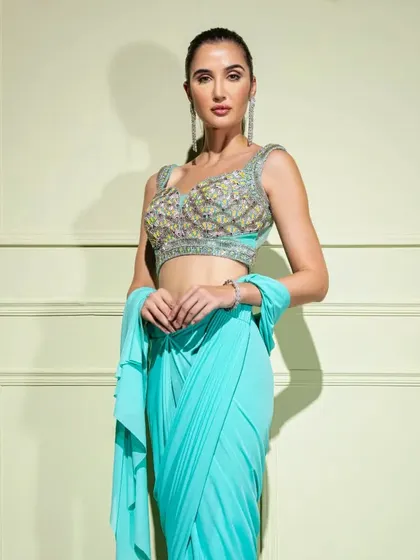 A closer look at the turquoise drape saree, highlighting the multi-color embroidery on the blouse.