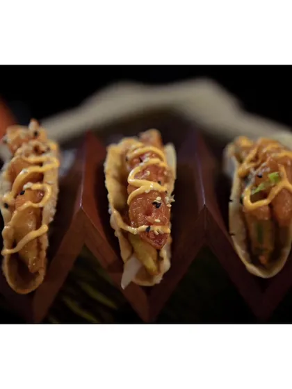 Our Korean Avocado Taco, featuring crispy fried avocado and fresh veggies in a fluffy taco shell, drizzled with a special sauce. A perfect fusion of flavors.