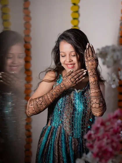 A creative portrait of the bride with her mehendi, using a reflection to add an artistic touch. It’s a unique way to capture this special pre-wedding ritual.