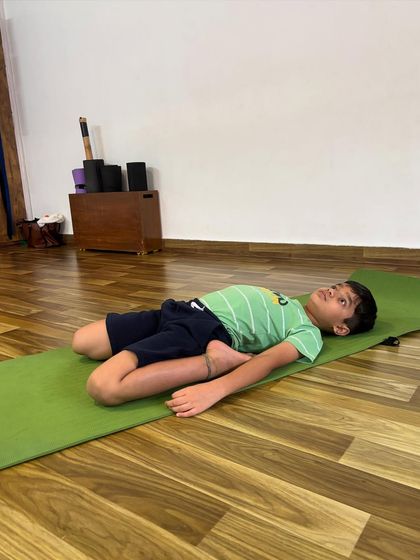 A moment of rest in Supta Baddha Konasana, or reclined bound angle pose. This restorative posture is a great way for kids to relax and calm their nervous system after an active class.