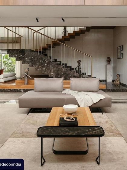 This shot from the Elle Decor feature captures the grand, open-plan living and dining area of Villa Shakthi. The dramatic staircase and double-height volume are central to the home's design, creating a sense of spaciousness and connection.