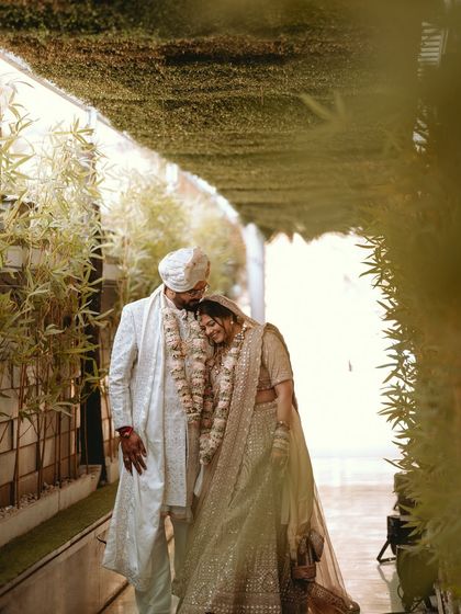 A quiet, intimate moment between the couple, walking through a green corridor after their ceremony.