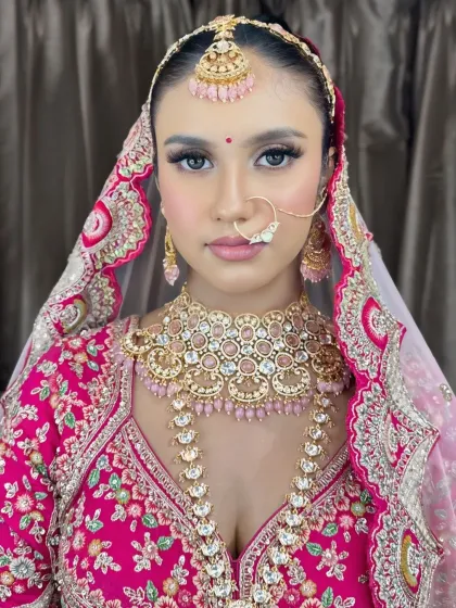 A full-face portrait of the bride, looking confident and radiant in her pink bridal attire.