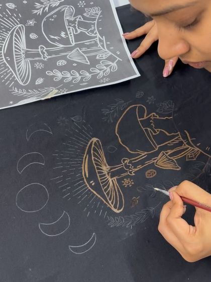 Using a stencil and a fine brush to create a detailed mushroom and moon phase design with bleach.