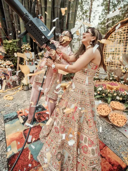 A playful moment from a Haldi ceremony, where the couple is showered with confetti from a party cannon. It's all about capturing the fun and unique elements of your celebration.