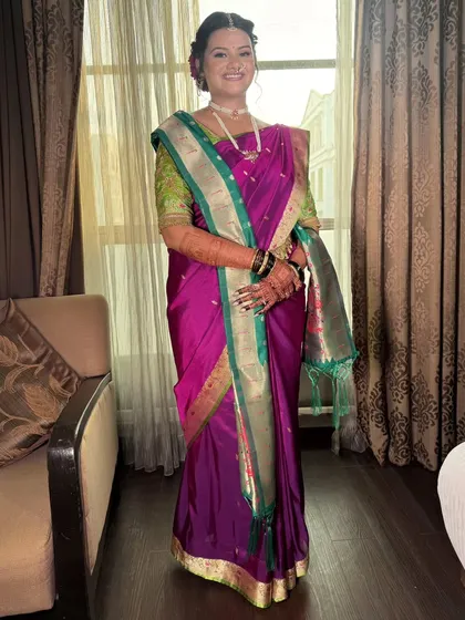 Adorned in tradition and wrapped in grace. This bride shines in a rich purple Paithani saree with a contrasting green and gold border, perfectly draped for her special day.