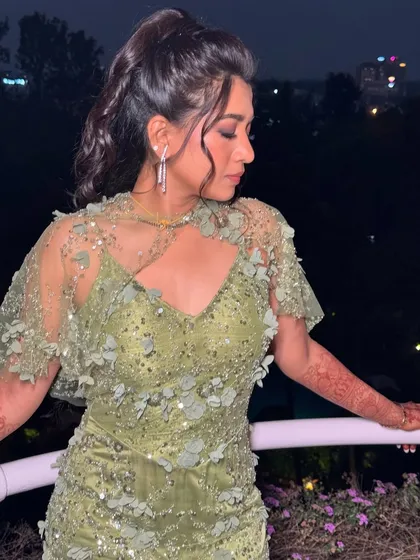 A glamorous half-ponytail with face-framing tendrils, perfect for a reception or cocktail party.