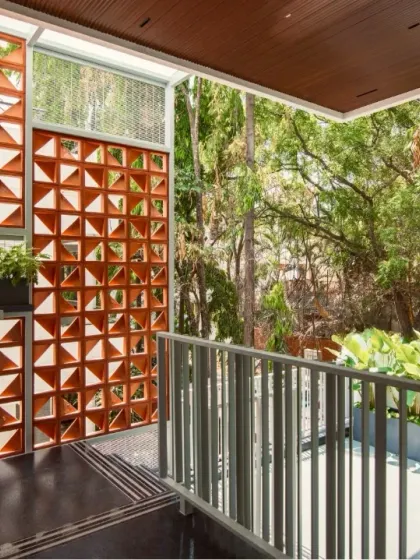 Our designs often incorporate traditional elements with a modern twist. This terracotta jaali screen provides natural ventilation and creates beautiful light patterns, while seamlessly integrating the home's exterior with the lush, green landscape.