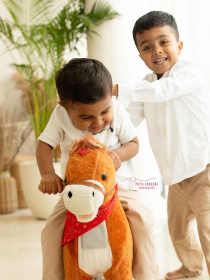 The moments we live for! Pure joy and laughter as two brothers play together on a toy horse during their fun-filled studio photoshoot.
