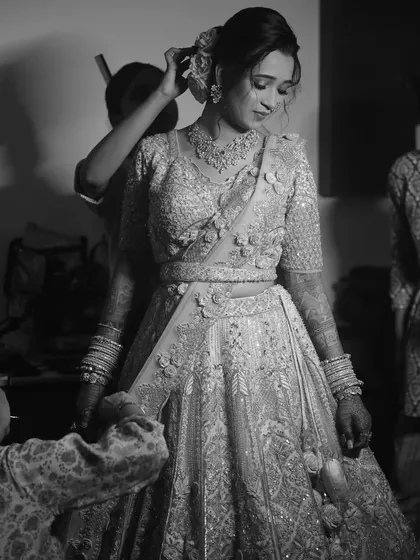A black and white photo capturing the final touches of the draping process.