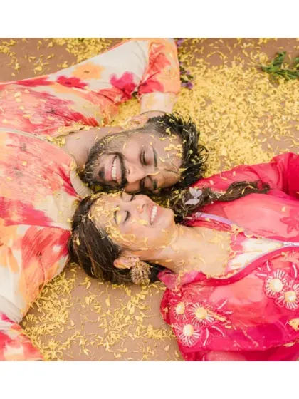 A dreamy, peaceful moment after the Haldi rituals. Lying amongst flower petals, this shot captures the happy exhaustion and intimate connection of the couple.