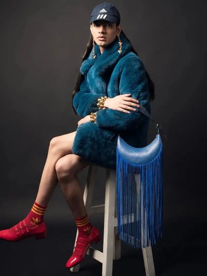 Our Selena Fringe bag in a stunning Blue Azure, styled for a high-fashion photoshoot. The dramatic fringe adds movement and a bold statement to the classic crescent shape.