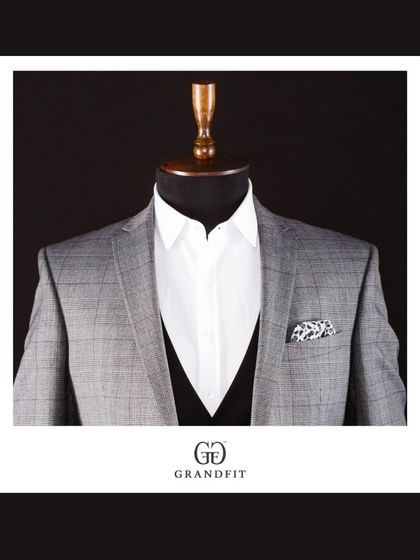 A close-up of the grey plaid jacket, worn open over a waistcoat to show the layering possibilities and the clean lines of the tailoring.