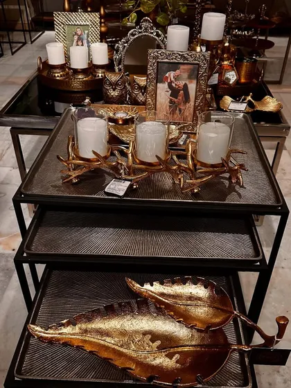A display in my store showing how different metallic pieces can be layered. The branched candle holder and large leaf-shaped platters create a stunning tablescape for any celebration.