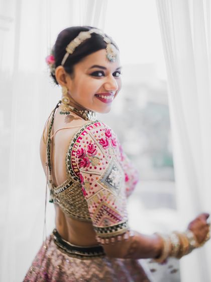 A happy bride looks over her shoulder, smiling at the camera. Her joy and excitement are palpable in this beautiful portrait.