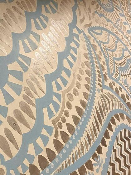 A detailed, angled shot of the Delhi mural. The patterns are inspired by traditional Indian textiles and motifs, reinterpreted in a modern, minimalist style.