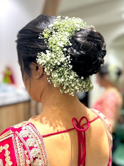 Another angle of the beautiful baby's breath floral bun, showing the neat finish and how it complements the bride's red blouse.