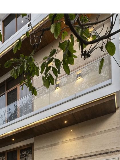 A detail shot of the clean lines and elegant material palette of a contemporary residence, featuring wooden soffits and glass railings.