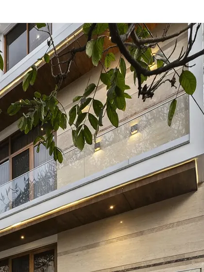 A detail shot of the clean lines and elegant material palette of a contemporary residence, featuring wooden soffits and glass railings.