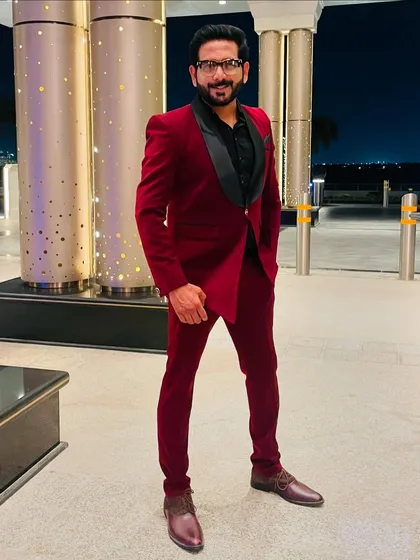Full-length view of my red tuxedo for a Dubai reception. I work with stylists to create a look that is both impactful and appropriate for the event's theme.