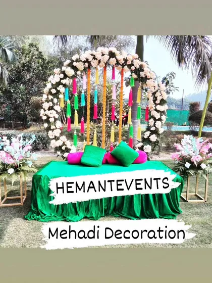 This is a simple and fresh outdoor Mehendi seating area. I used a green velvet-covered divan with a colorful floral arch backdrop, perfect for a garden or farmhouse event.
