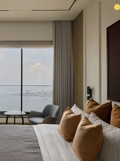 The master bedroom at 'Pad by the Bay' offers a serene escape with stunning views of the Mumbai sea link. We used autumnal tones and oak veneers to create a warm, inviting atmosphere, perfect for unwinding at the end of the day.