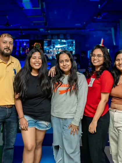 A group of friends posing for a photo on the checkered floor.