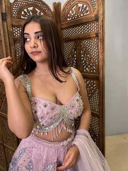 A beautiful portrait shot highlighting the stunning blouse and the soft, romantic feel of this pre-loved lehenga.