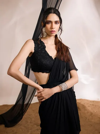 A poised shot of the Eve Saree Set, highlighting the contrast between the textured, hand-embellished blouse and the smooth, draped saree.