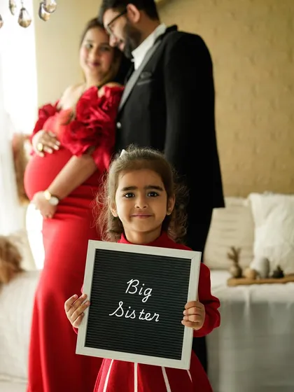 The proud big sister takes center stage. Using props like this letter board is a fun way to announce her new role and make her feel like a special part of the photoshoot.