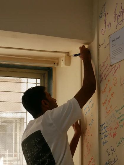 A project leader adds his thoughts to the "Happiness Wall." These meetings are about renewing excitement and enthusiasm for our shared mission.