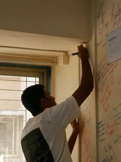 A project leader adds his thoughts to the "Happiness Wall." These meetings are about renewing excitement and enthusiasm for our shared mission.