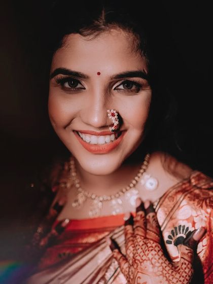 A radiant bridal portrait. The bride's genuine, happy smile is infectious, and the lighting beautifully captures the glow on her face and the sparkle of her jewellery.