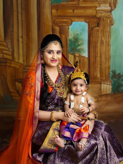 Another beautiful mother and child portrait celebrating Janmashtami. The mother's expression of pride and the baby's adorable costume are perfectly captured.