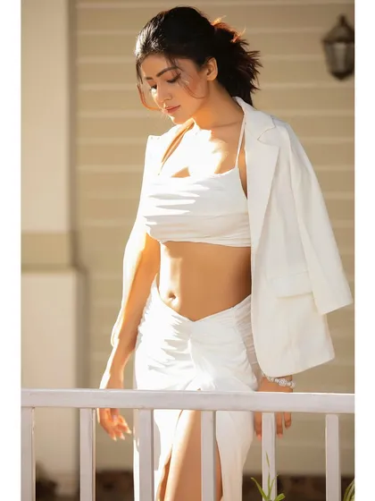 A candid-style shot with a white blazer draped over the shoulders. This adds a layer of effortless sophistication to a casual look.