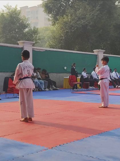 Two young students facing off during a patterns (Tul) competition at the Delhi State Championship.