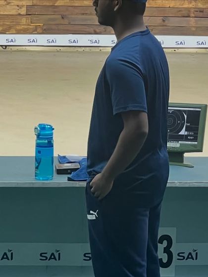 A coach observes a shooter during the Karnataka State Championship 2025, with the SCATT system providing live feedback in the background.