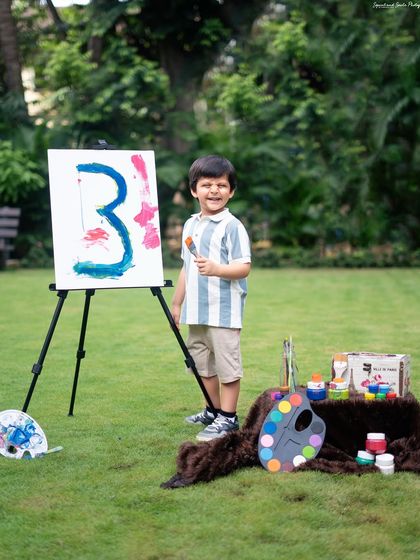 Proudly standing by his artwork. This portrait captures the happy and confident spirit of a three-year-old.