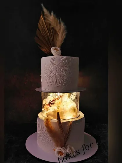 The same two-tier illuminated cake in a darker setting, showing how the lights create a magical and luxurious ambiance.