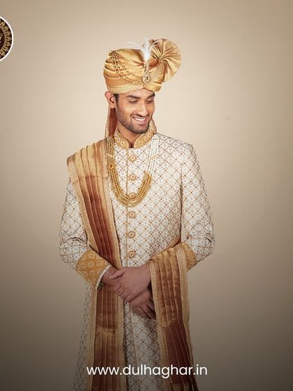 A smiling groom in our cream and gold sherwani, capturing the joy and elegance of the wedding day.