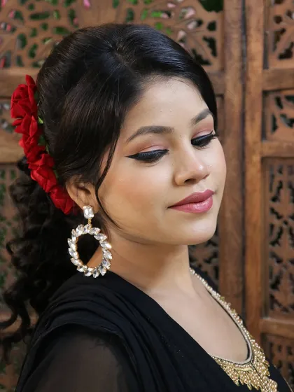 A classic party look with a winged liner, soft pink eyeshadow, and a beautiful floral hair accessory. This is a versatile look for any celebration.