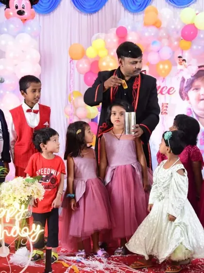 A group of young children gathered on stage with me at a Mickey Mouse themed birthday party. Their curiosity and excitement are contagious.