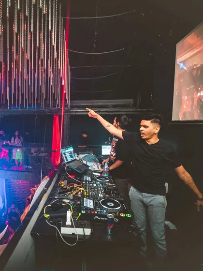 Pointing out to the massive crowd from an elevated DJ booth.