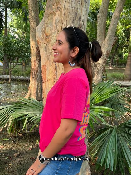 Another angle of the blue 'Naazakat' hoops in a park setting. They are perfect for adding a cool-toned pop of color to your look.