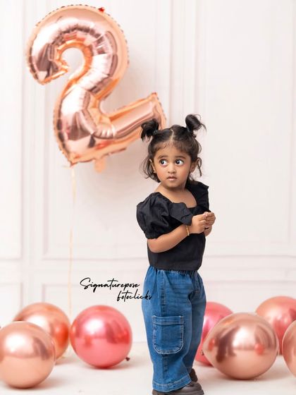 A slightly different angle of the stylish two-year-old's birthday shoot, highlighting her thoughtful expression.