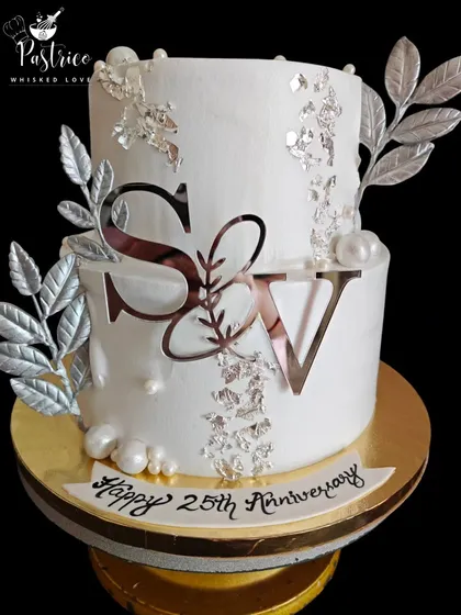 For a 25th anniversary, I designed this elegant and modern two-tiered cake. The clean white fondant, silver leaf details, and custom monogram create a sophisticated look that honours such a special milestone.