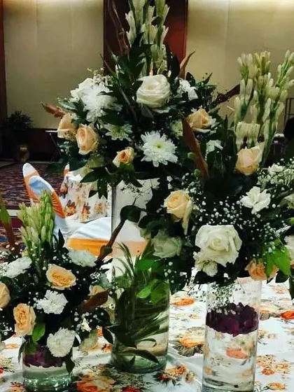 A close-up of a table centerpiece from a hotel event. I used a mix of fresh white roses, chrysanthemums, and tuberoses in glass vases to create a classic and fragrant floral arrangement for each table.